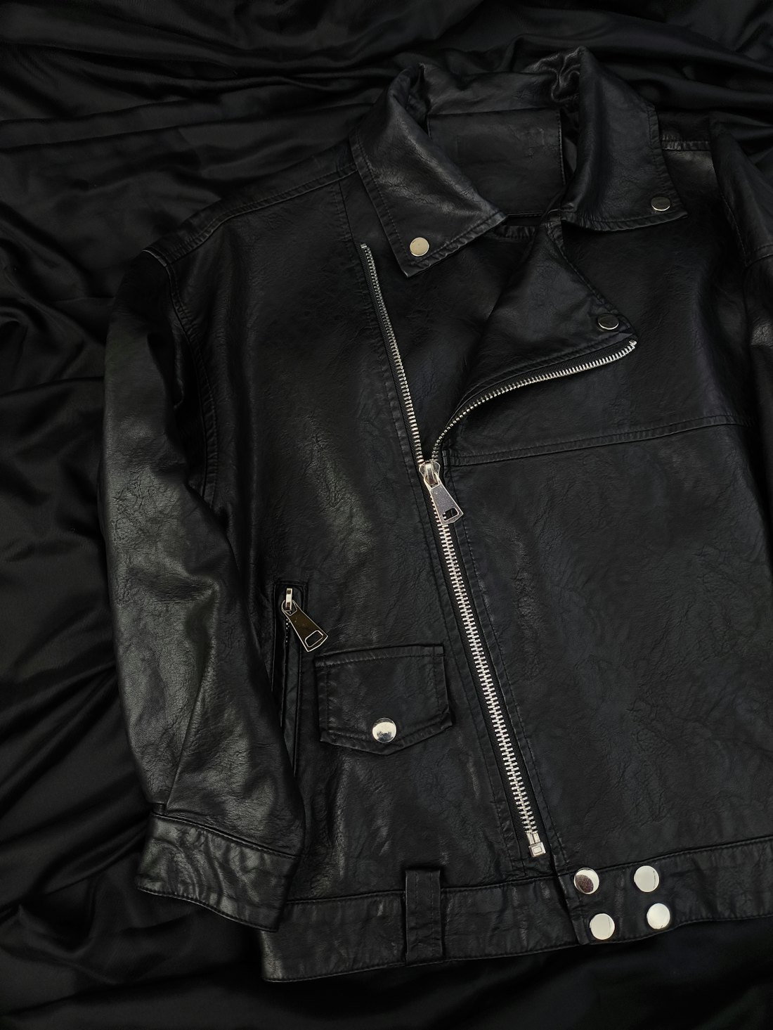 Jaket kulit hitam di atas kain hitam